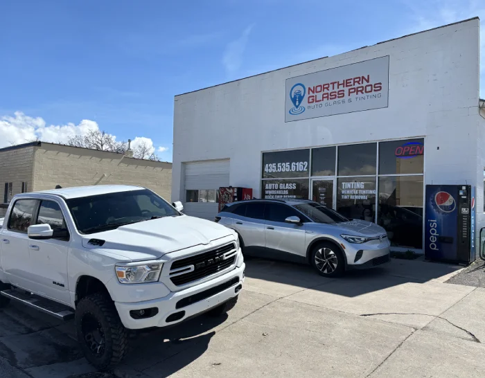 Northern Glass Pros storefront location. A white cinder block building with large windows and a single bay door.