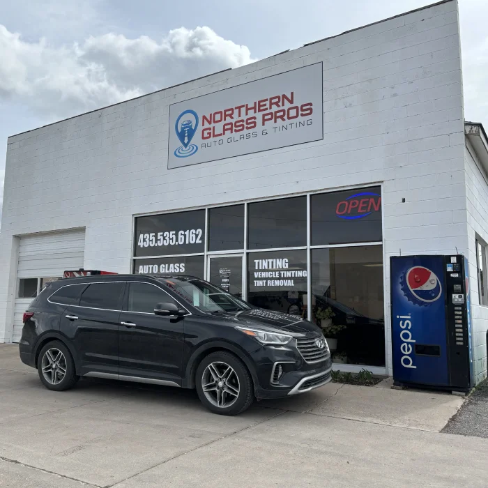 Northern Glass Pros store front. White cinderblock building with a glass windows and a bay door.