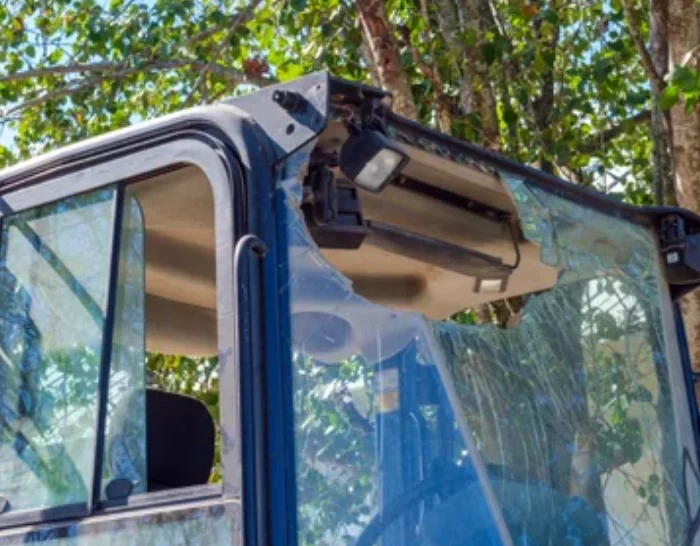 Backloader with close up of window that is broken with a big hole in it.