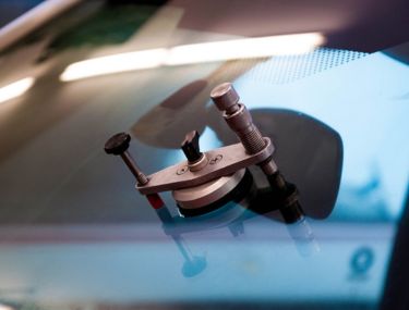 Close up of windshield rock chip repair tool attached to front windshield.