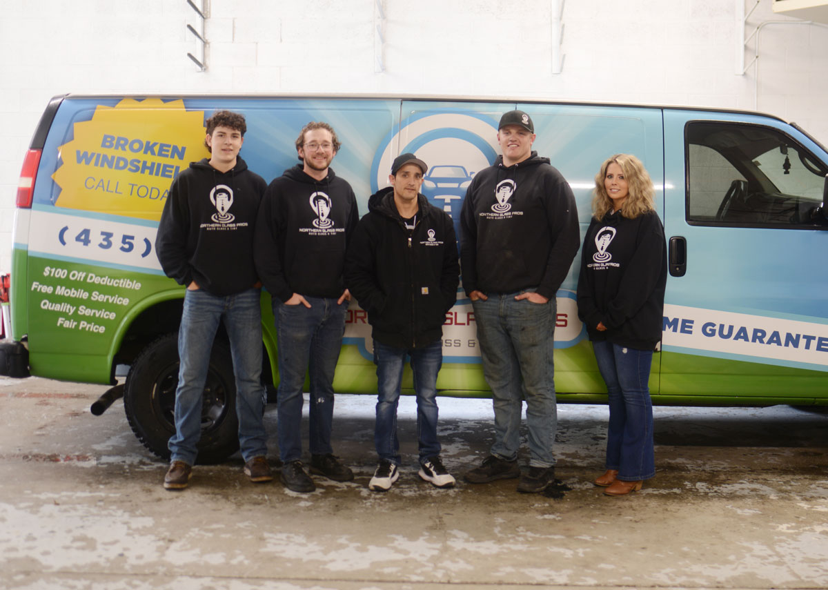 The full team from Northern Glass Pros standing in front of the company van for a group photo.