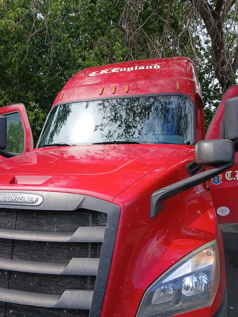 Red ford diesel truck with a shiny new window.