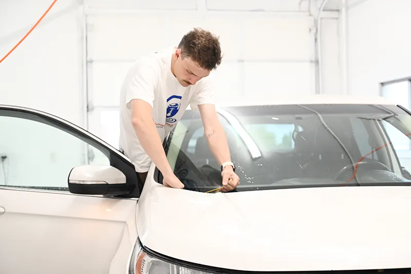 Auto glass repair technician installing a windshield.